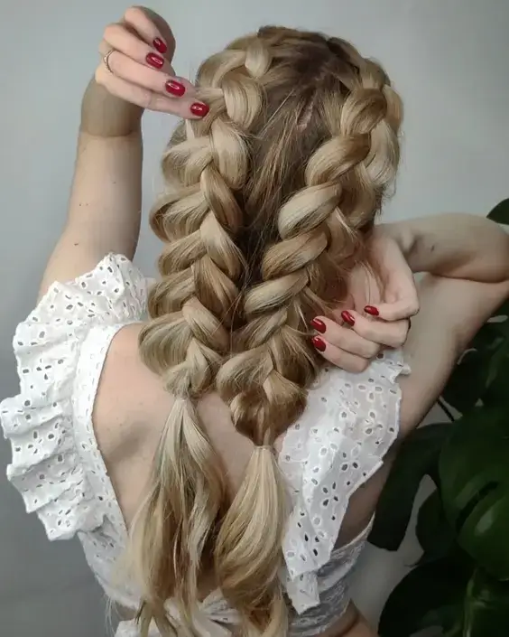 Dva hrubé francúzske vrkoče, dlhé blond vlasy, pohľad zozadu.